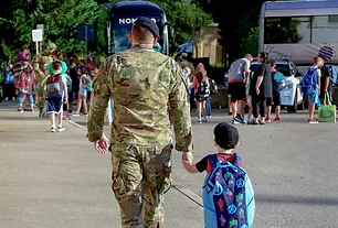 a person in military uniform holding a child's hand